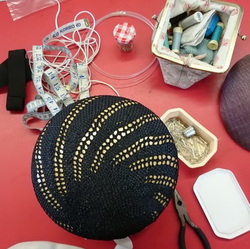 Navy blue straw blocked over a large button shaped hat block