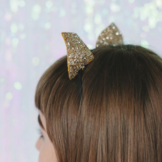 Close up, showing sparkly ears poking through model's hair.