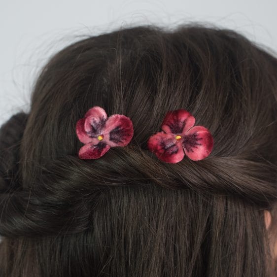 Close up of Delicate, Wine Red Hair Flowers, worn in a twisted half up do. By Imogen's Imagination.