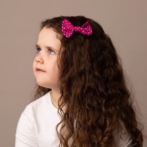 Hot Pink Polka Dot Hair Clip worn by a child with a long curly hair