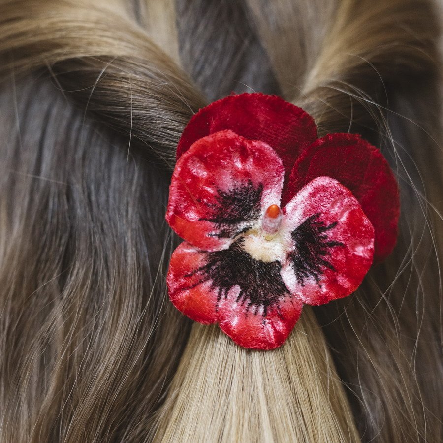 Close up of rich red, velvet pansy hair accessory