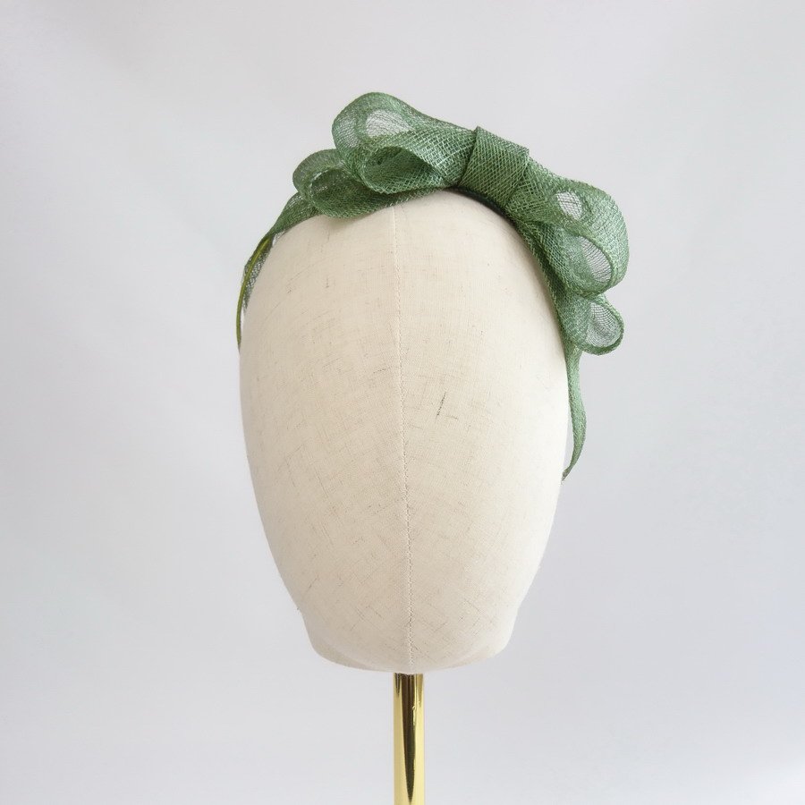 Green Bridesmaid Hair Accessories - Front view of Green Large Sinamay Bow Fascinator, worn to the left.