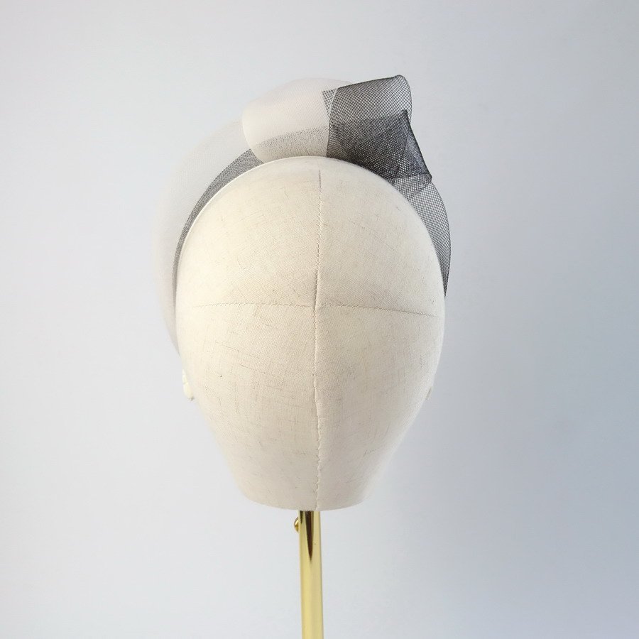 Back view of an Ivory Black Mesh Knotted Headband worn to the right of the head