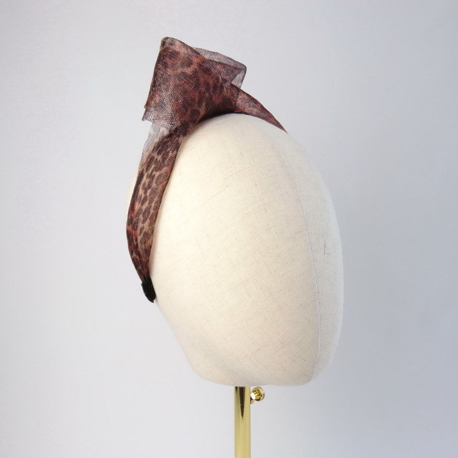 Leopard print contemporary headband worn to the right of the head