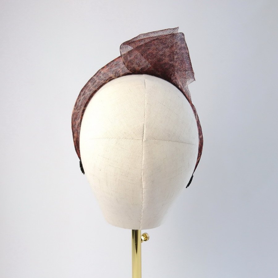 Back view of leopard print mesh knotted hair accessory worn to the right of the head