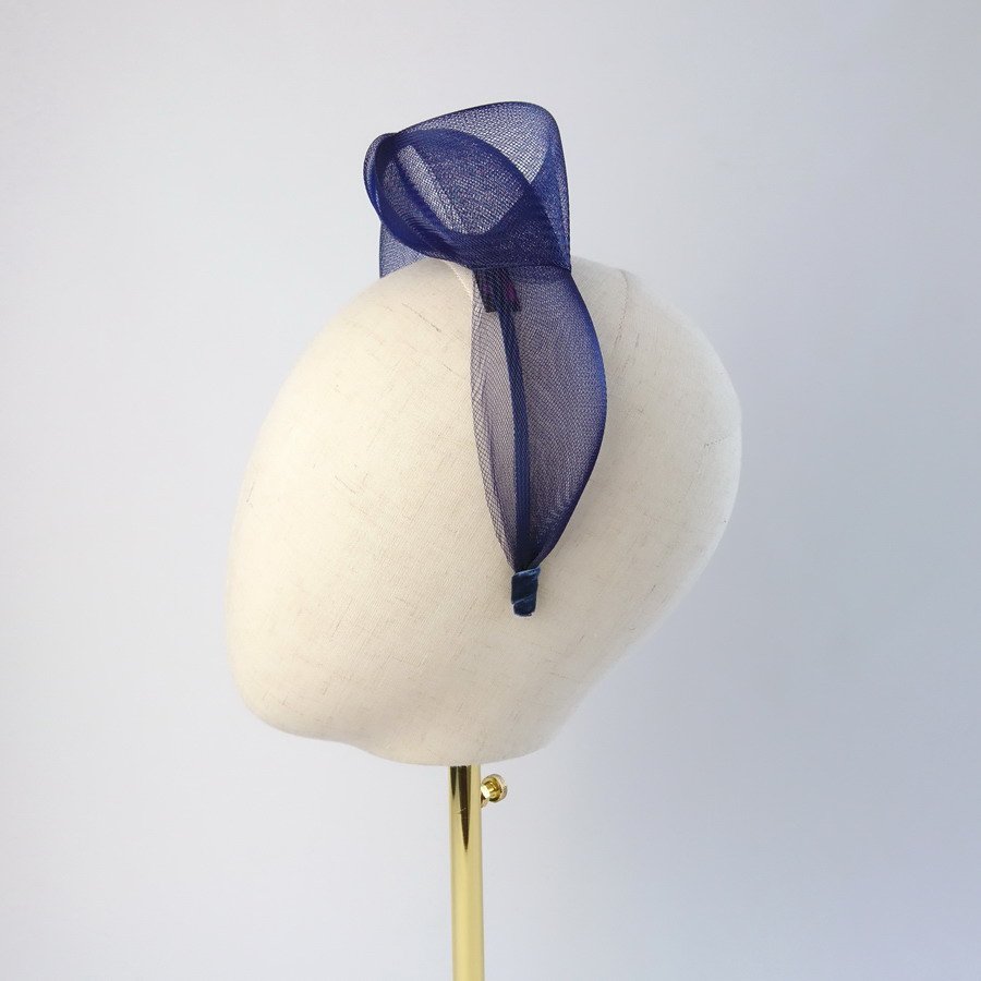 Navy blue vegan friendly knotted headband worn to the left of the head