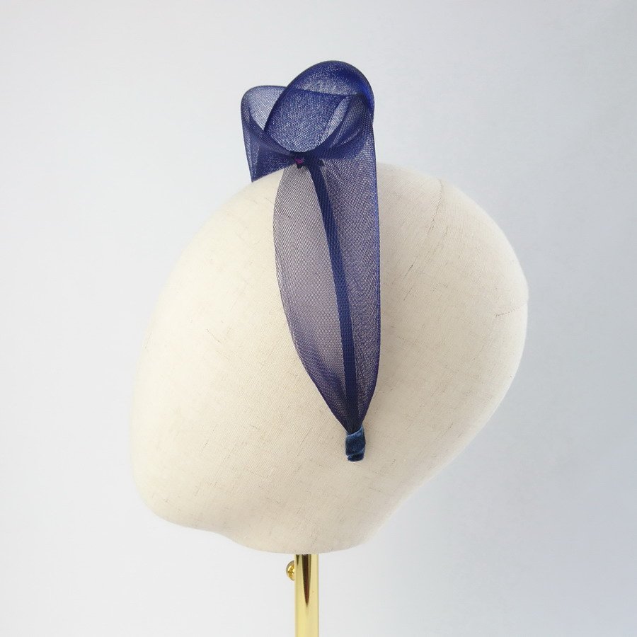 Navy blue contemporary headband worn to the right of the head