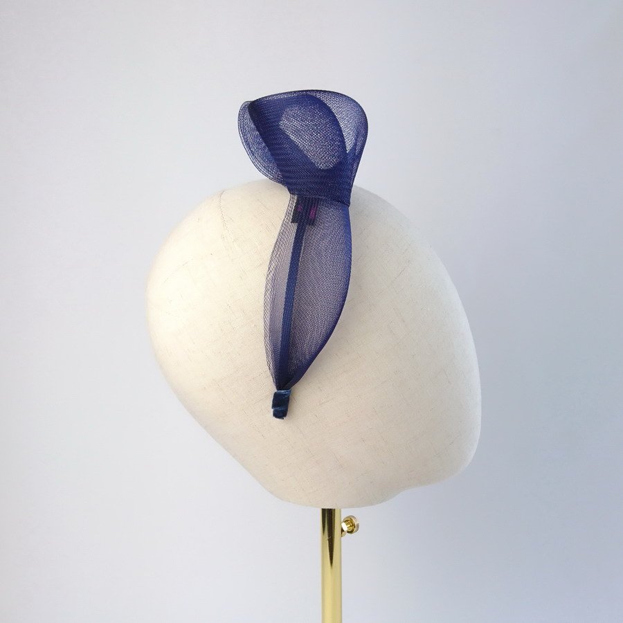 Navy blue vegan friendly knotted headband worn to the right of the head