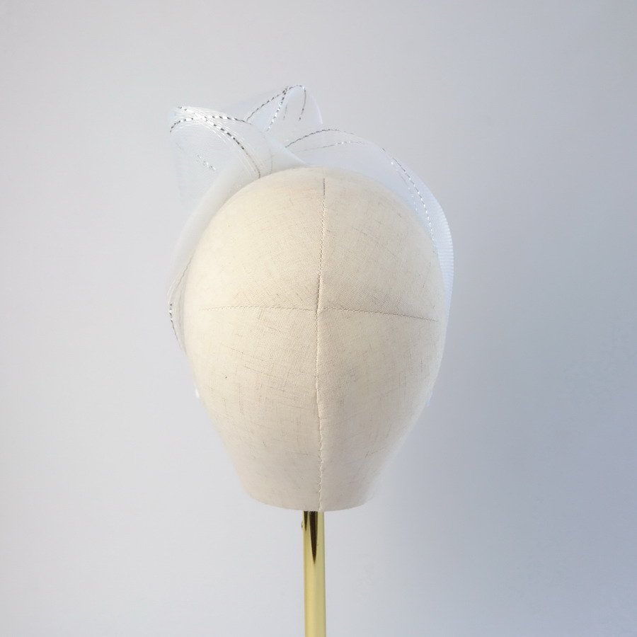 Back view of a white and silver contemporary headband worn to the left of the head