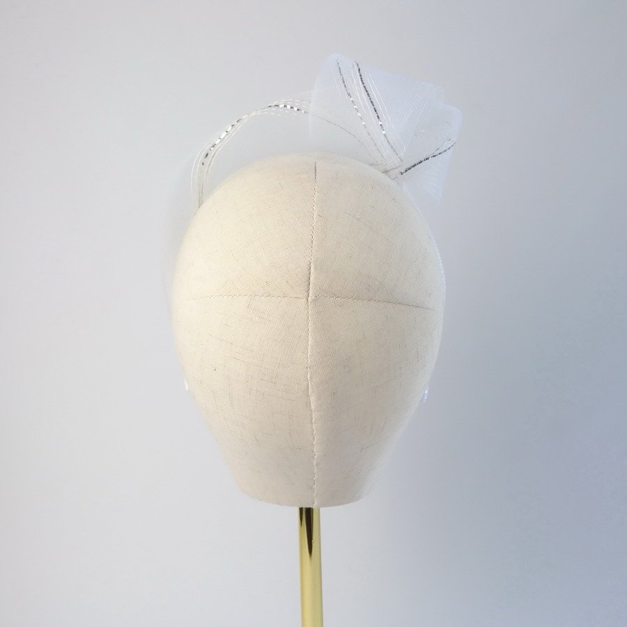 Back view of a white and silver contemporary headband worn to the right of the head