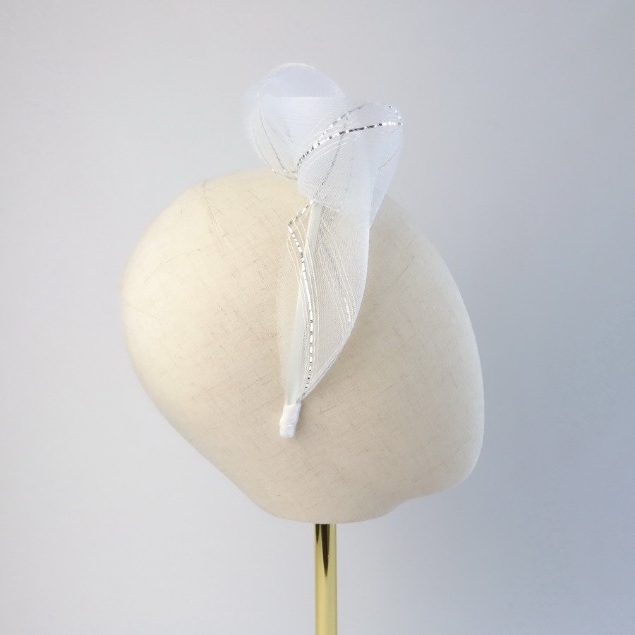 White and silver knotted bridal hair accessory worn to the right of the head