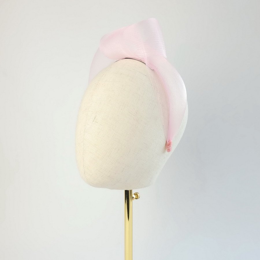 Pale pink vegan friendly knotted headband worn to the left of the head