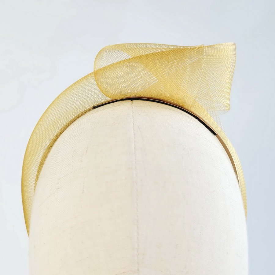 Mustard statement knot headband worn to the left of the head
