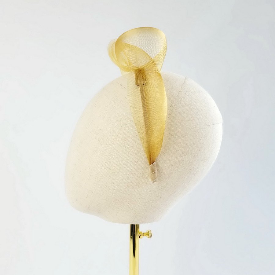 Mustard contemporary headband worn to the left of the head