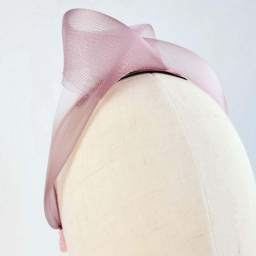 Dusky pink contemporary headband worn to the right of the head