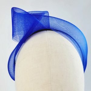 Royal blue vegan friendly knotted headband worn to the right of the head