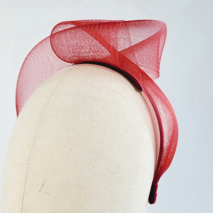 Wine red vegan friendly knotted headband worn to the left of the head