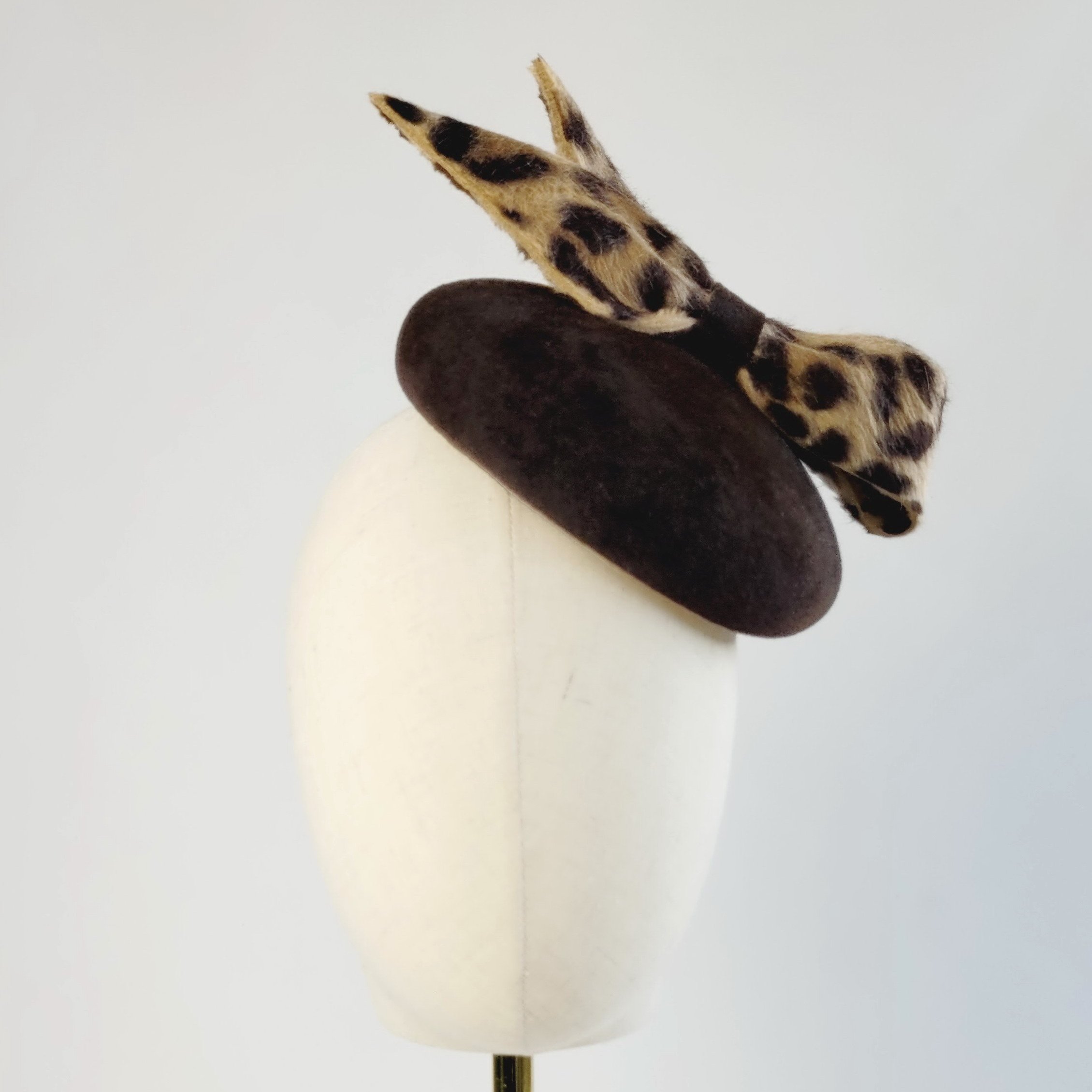 Brown Felt Button Hat with Leopard Print Bow worn to the left of the head handmade by Imogen's Imagination