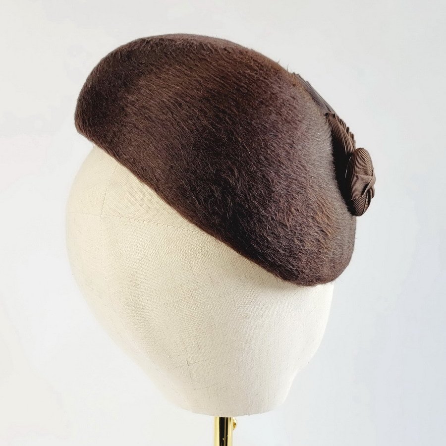 Back view of a brown felt hat trimmed with vintage inspired ribbon decoration