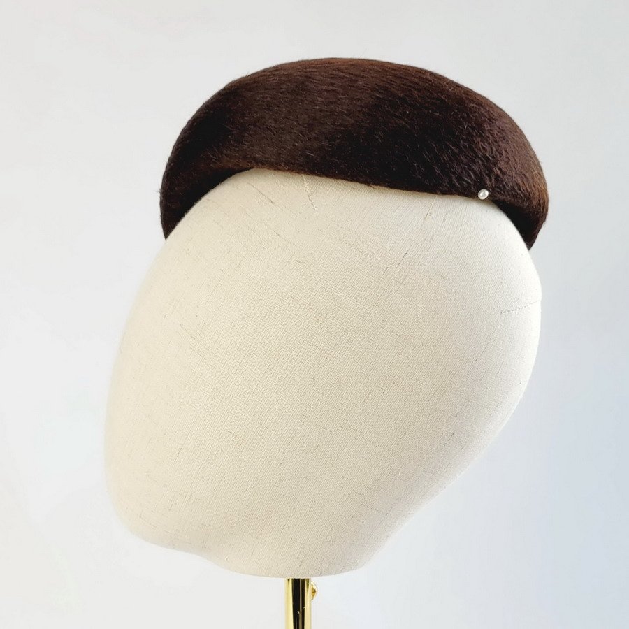 Side view of a brown felt cocktail hat made using reclaimed vintage materials