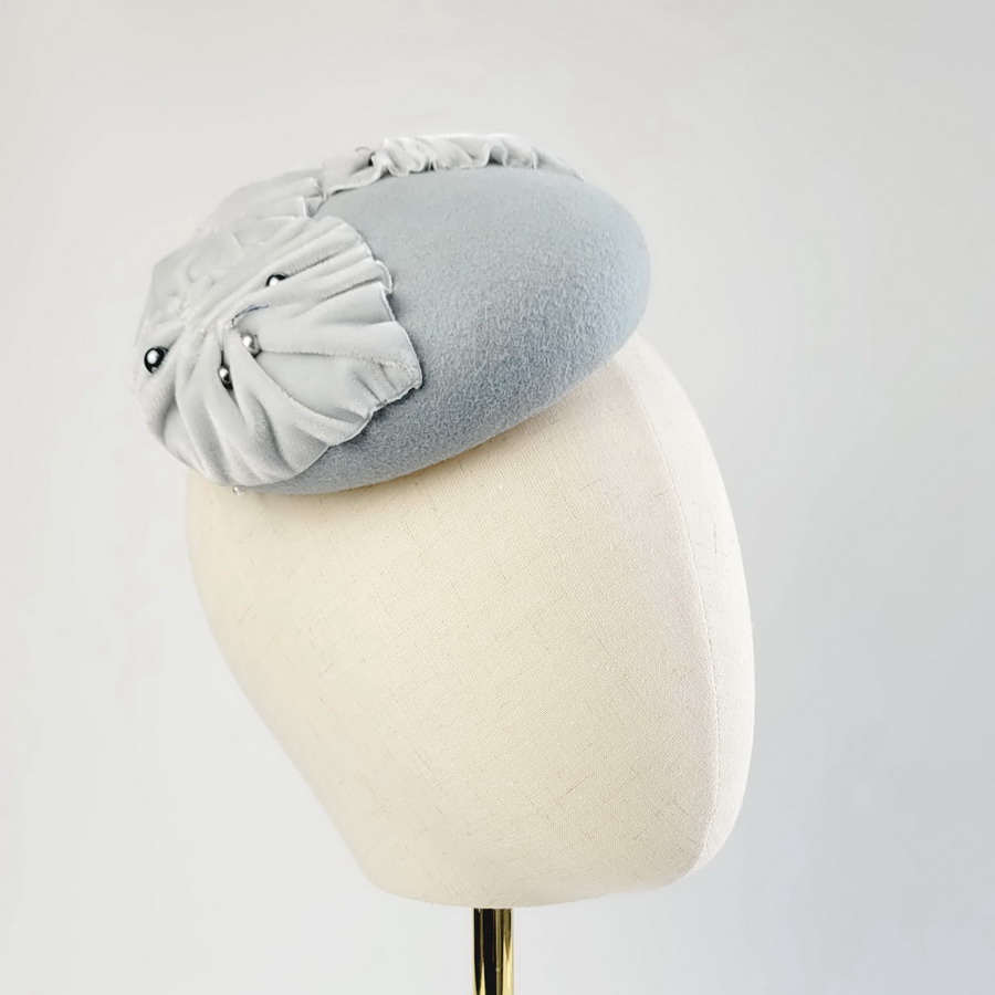Ice Blue Felt Button with Velvet Leaves and Pearls worn to the right of the head
