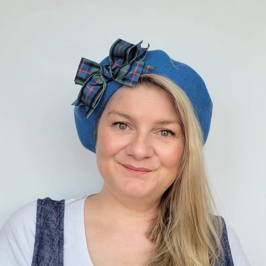Airforce Blue Beret with Flower of Scotland Tartan Ribbon Bow worn by a white woman in her 40s with long blonde hair