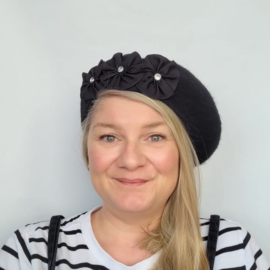 Black Beret with Ribbon Rosettes and Diamante worn by a white woman in her 40s with long blonde hair