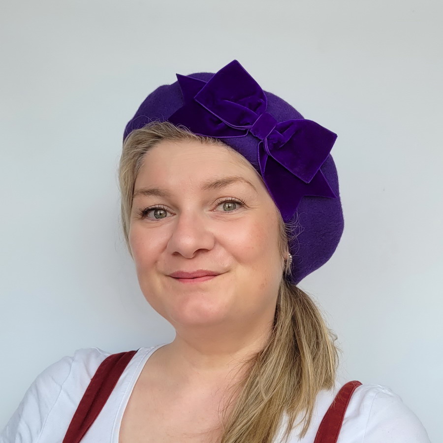 Purple Beret with Purple Velvet Ribbon Bow worn by a white woman in her 40s with long blonde hair